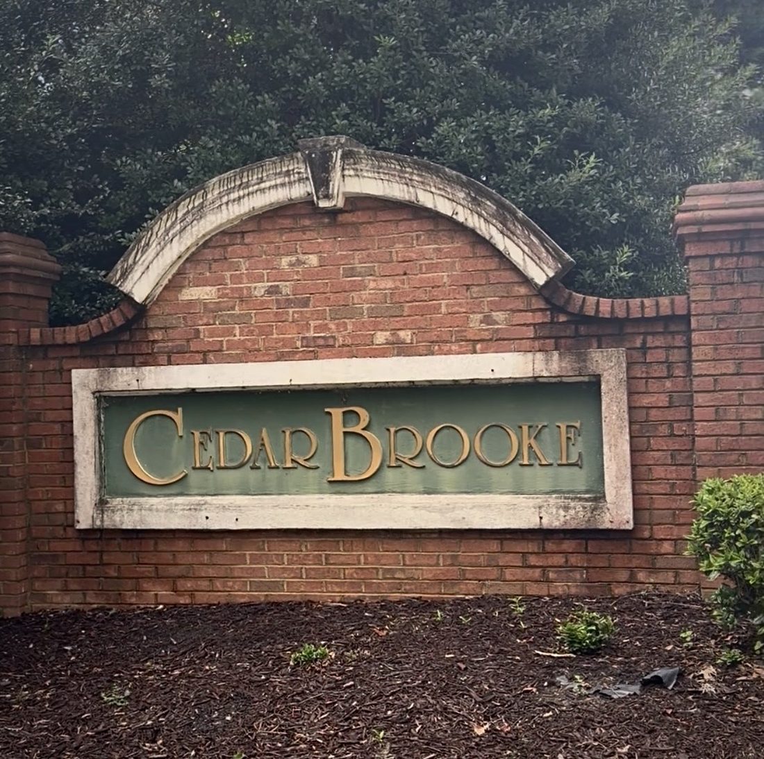 Cedar Brooke neighborhood entrance sign before cleaning, black mildew on the arch and frame, Greenwood SC